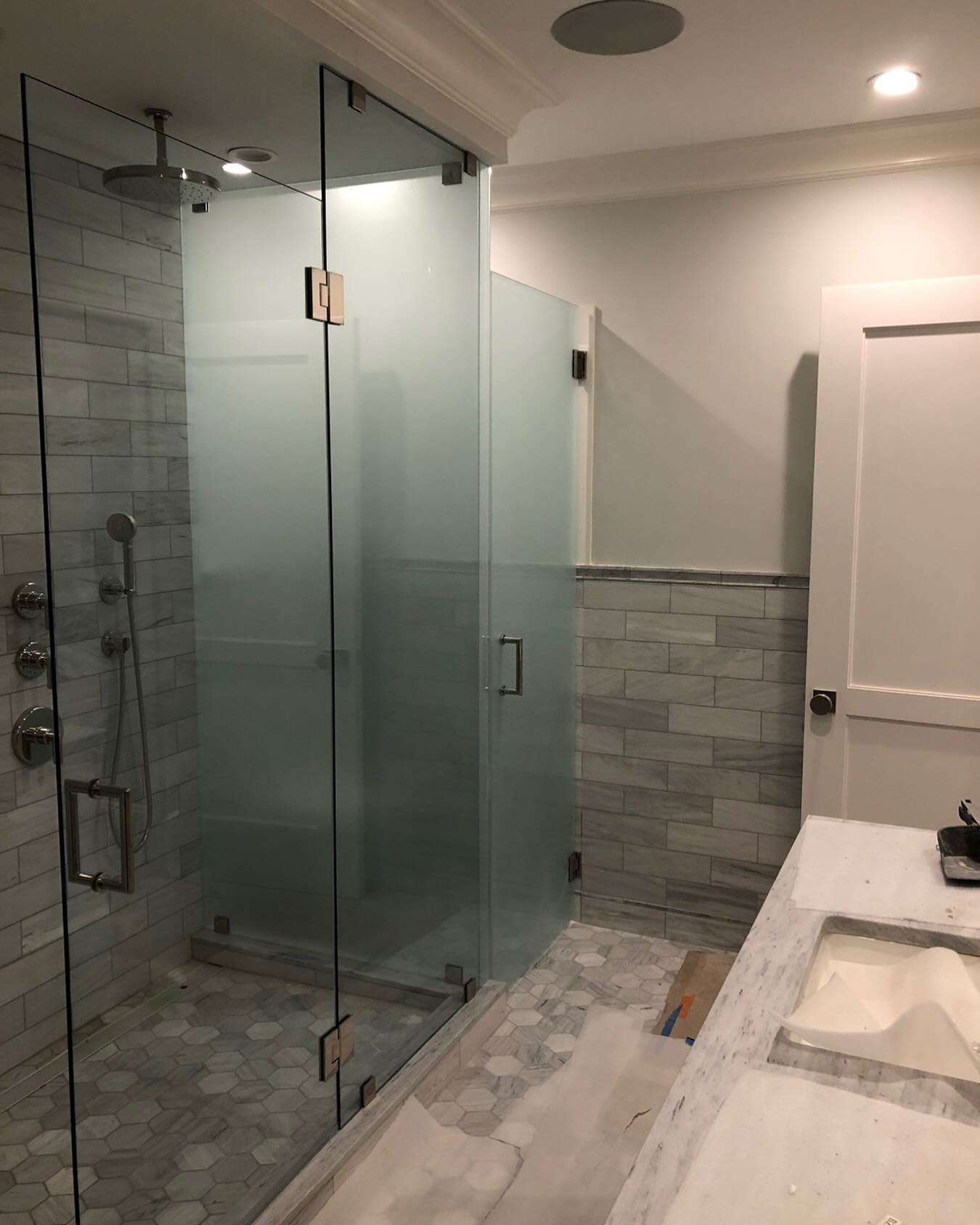 Custom enclosure with an attached water closet feature using acid etched glass to wrap up this bathroom remodel.